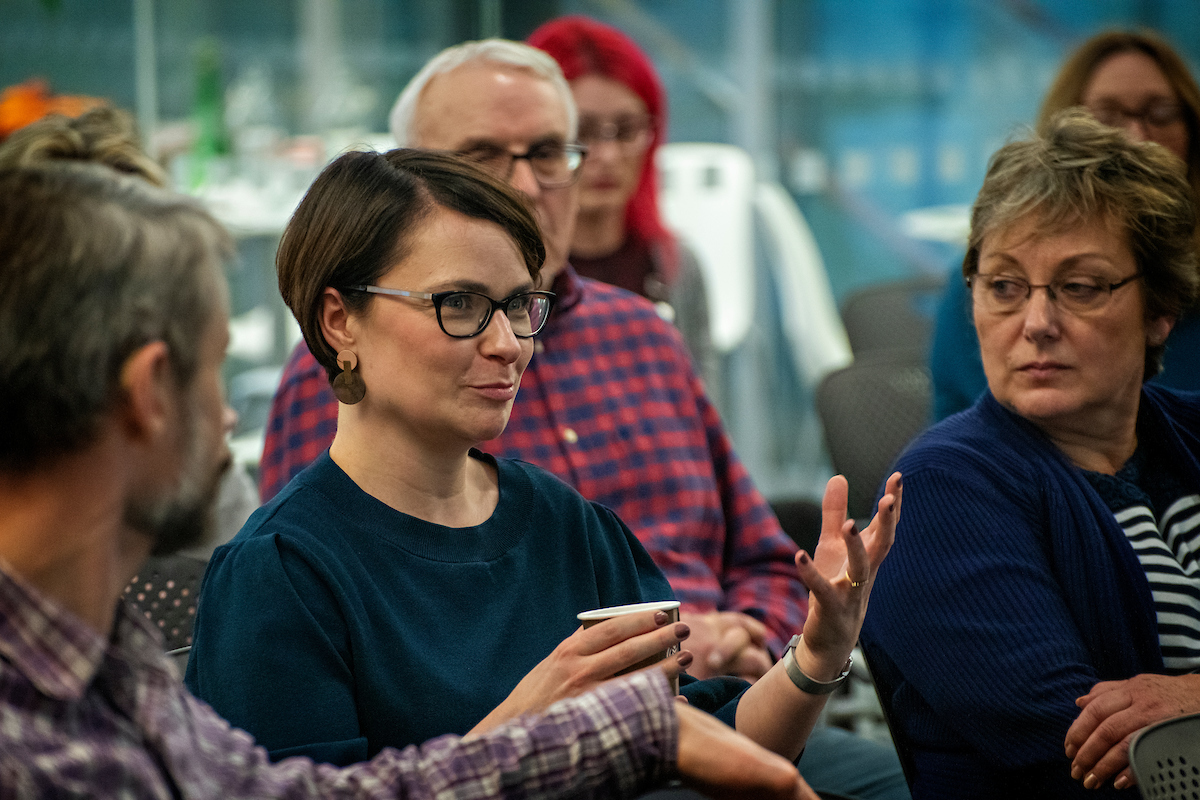 Woman sitting in the audience speaking.